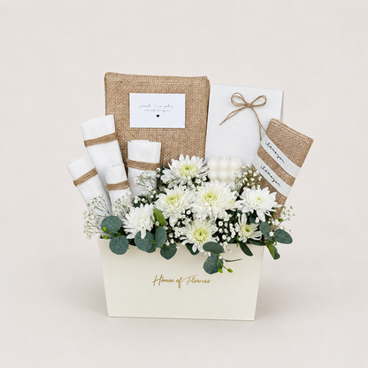 A floral gift basket arrangement from House of Flowers, featuring white chrysanthemums, green eucalyptus, white baby&