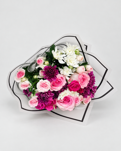 Bouquet of white flowers in a teal wrap on a gray surface with &