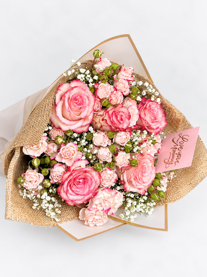 With all my Heart bouquet with pink roses and gypsophila, wrapped in kraft and white paper with a "Love You Mommy" card